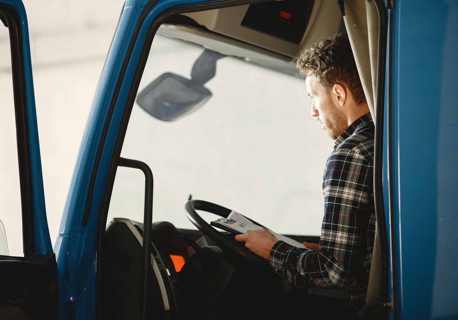 Driver in the cab reviewing paperwork before rolling